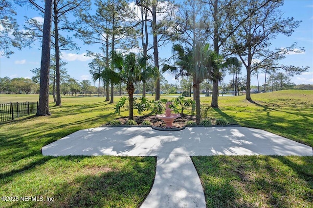 view of home's community featuring a lawn and fence