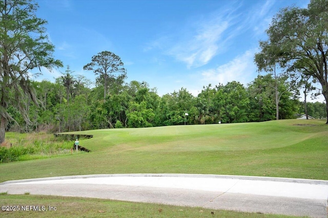 view of home's community featuring a lawn and golf course view