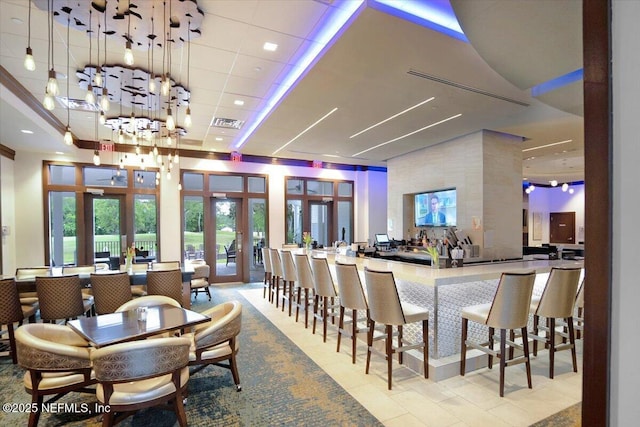 dining room featuring visible vents, french doors, a high ceiling, and a drop ceiling