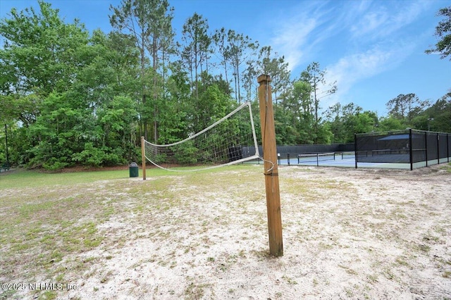view of yard with a tennis court and fence
