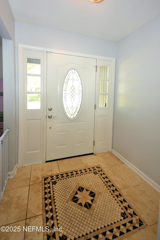 foyer featuring baseboards and light tile patterned flooring