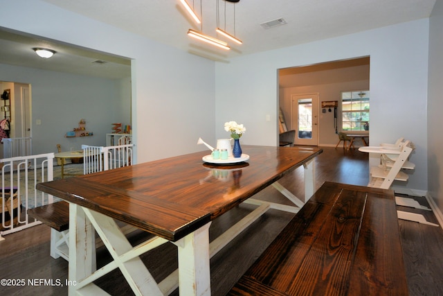 dining area featuring visible vents, baseboards, and wood finished floors