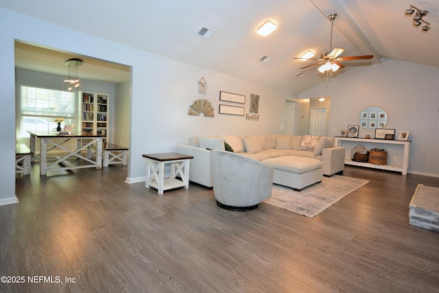 living area featuring visible vents, baseboards, a ceiling fan, dark wood finished floors, and vaulted ceiling with beams