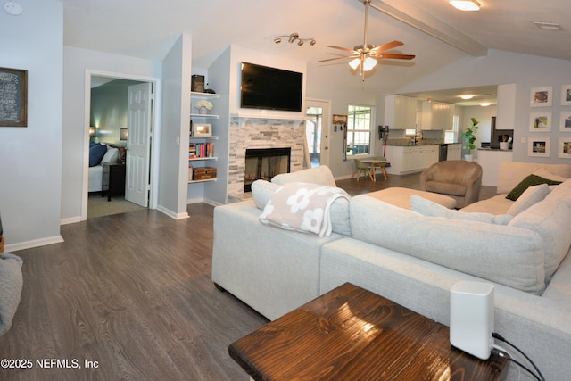 living area featuring a fireplace, dark wood-style floors, visible vents, ceiling fan, and vaulted ceiling with beams