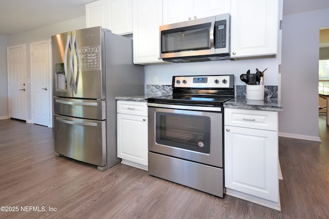 kitchen featuring white cabinets, wood finished floors, and appliances with stainless steel finishes