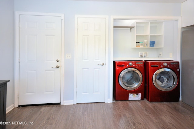 laundry room with laundry area, separate washer and dryer, wood finished floors, and baseboards