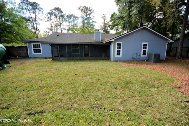 back of house with central AC, a sunroom, a yard, fence, and a chimney