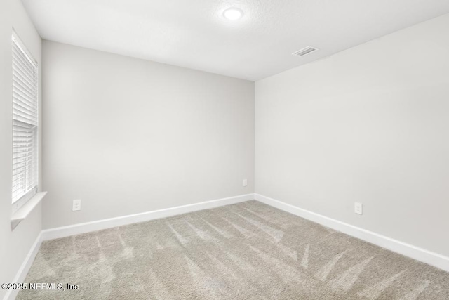 spare room featuring visible vents, baseboards, and carpet floors