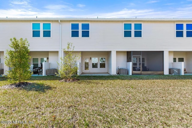 rear view of property featuring a patio area, a lawn, central AC, and a sunroom