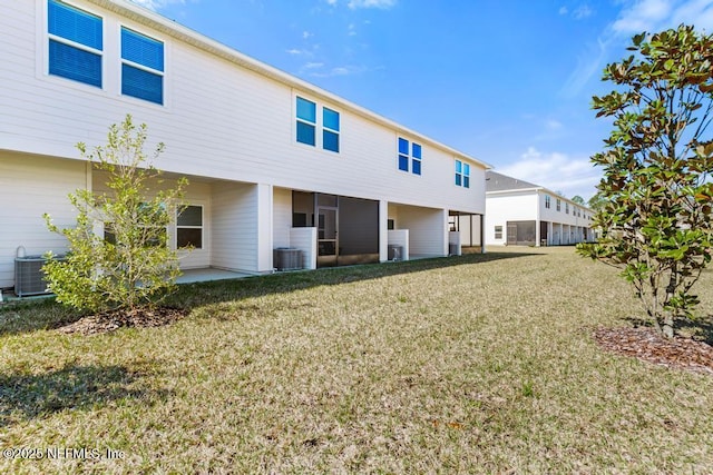 back of property with central air condition unit, a lawn, and a patio