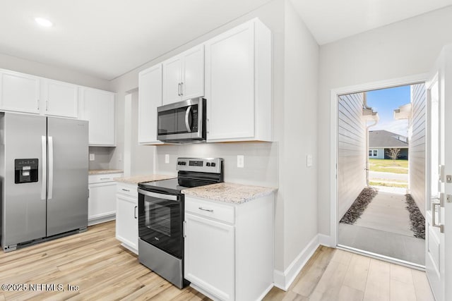 kitchen featuring stainless steel appliances, light wood-style floors, and white cabinetry