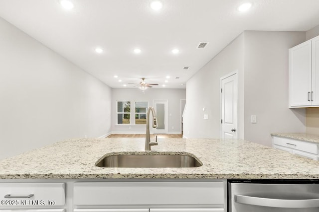 kitchen featuring a ceiling fan, a sink, stainless steel dishwasher, recessed lighting, and white cabinets
