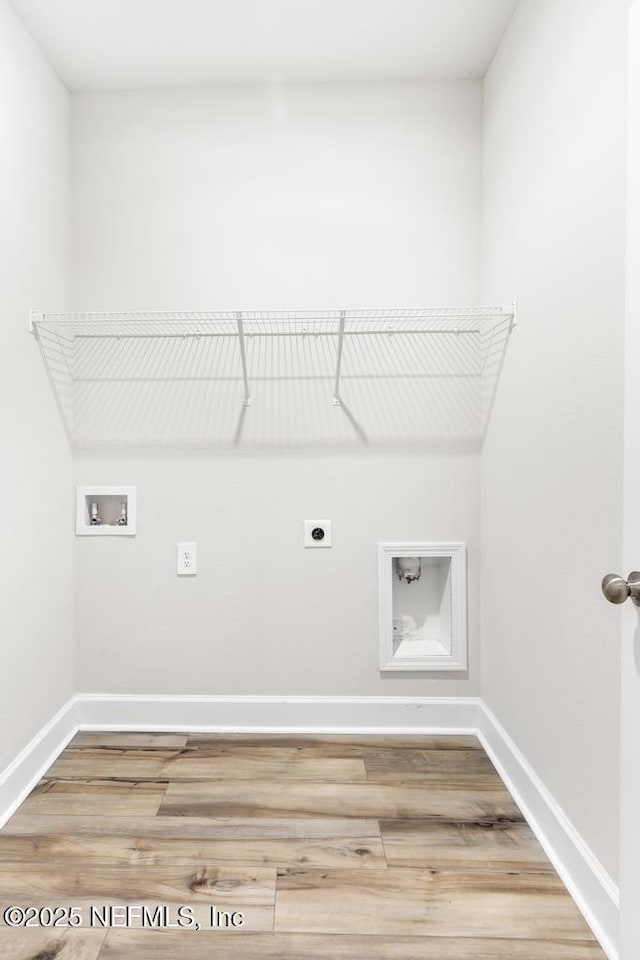 clothes washing area with baseboards, washer hookup, laundry area, wood finished floors, and hookup for an electric dryer