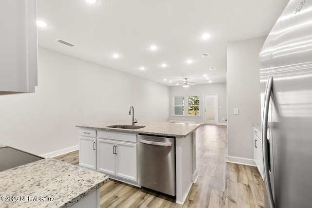 kitchen with light wood-type flooring, a sink, white cabinetry, appliances with stainless steel finishes, and ceiling fan
