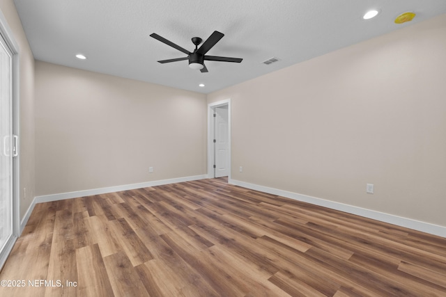 empty room with recessed lighting, a ceiling fan, visible vents, and wood finished floors