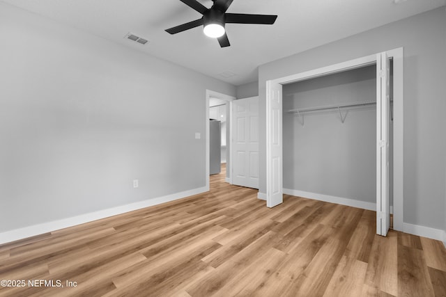 unfurnished bedroom featuring visible vents, a closet, light wood-style flooring, and baseboards