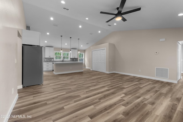 unfurnished living room with visible vents, ceiling fan, and light wood-style floors