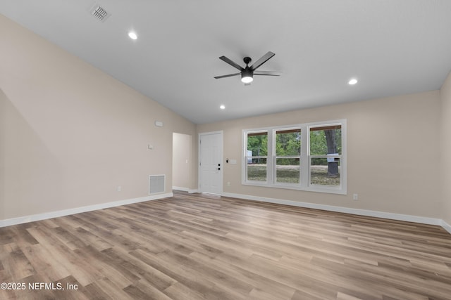 unfurnished living room featuring visible vents, a ceiling fan, light wood finished floors, and lofted ceiling