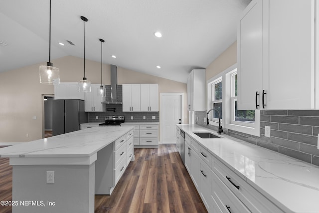 kitchen with a sink, stainless steel appliances, a center island, vaulted ceiling, and wall chimney exhaust hood