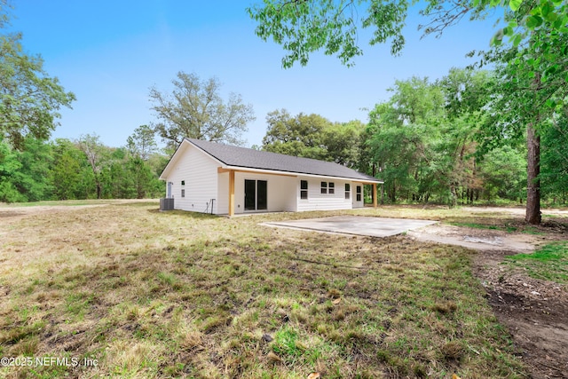 rear view of house featuring a lawn, cooling unit, and a patio