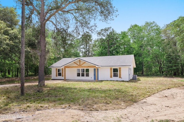 ranch-style home featuring cooling unit and a front lawn