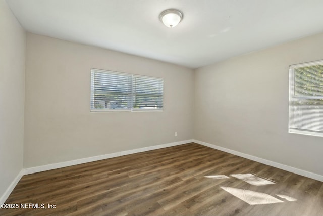 empty room with baseboards and wood finished floors