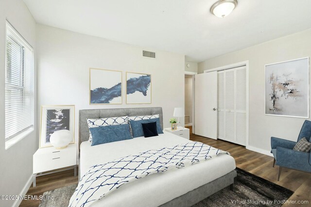 bedroom featuring baseboards, visible vents, a closet, and wood finished floors