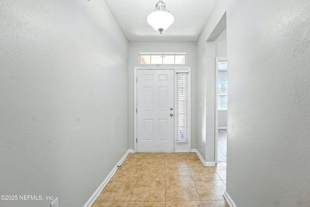foyer featuring light tile patterned floors and baseboards