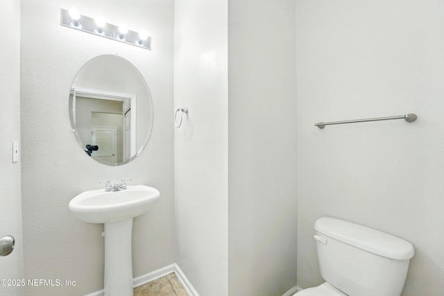 bathroom featuring toilet and baseboards