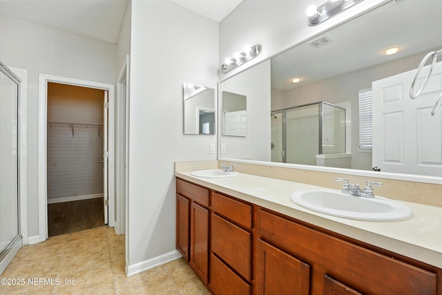 bathroom with a shower stall, visible vents, and a sink