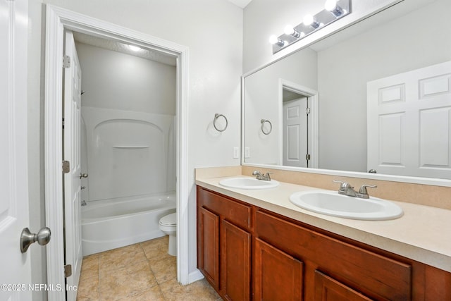 full bathroom featuring double vanity, toilet, tile patterned floors, and a sink