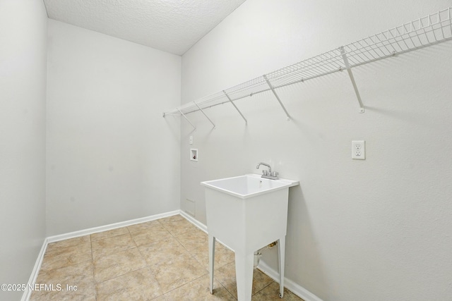 washroom featuring light tile patterned floors, baseboards, laundry area, washer hookup, and a textured ceiling