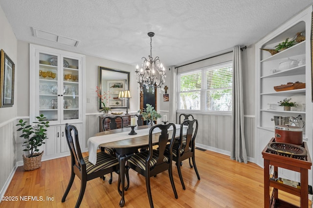 3079 Anderson Rd, Green Cove Springs, FL 32043 - dining area featuring visible vents, a textured ceiling, light wood-style flooring, and a notable chandelier