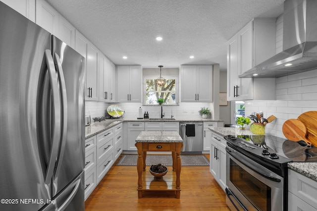 3079 Anderson Rd, Green Cove Springs, FL 32043 - kitchen featuring decorative backsplash, white cabinets, stainless steel appliances, wall chimney exhaust hood, and a sink