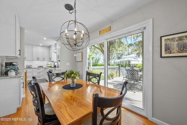 3079 Anderson Rd, Green Cove Springs, FL 32043 - dining room with baseboards, a textured ceiling, an inviting chandelier, and light wood-style flooring