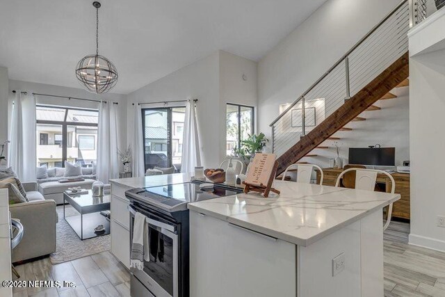 726 Spinnakers Reach Dr Unit 726, Ponte Vedra Beach, FL 32082 - kitchen with open floor plan, a center island, stainless steel electric range, a notable chandelier, and hanging light fixtures
