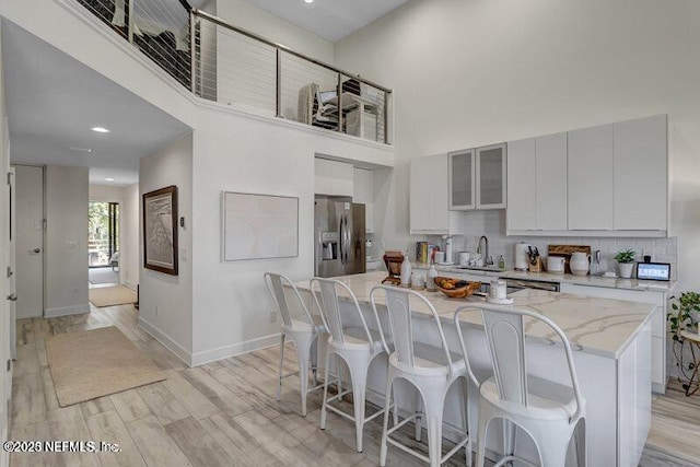 726 Spinnakers Reach Dr Unit 726, Ponte Vedra Beach, FL 32082 - kitchen with a sink, stainless steel fridge with ice dispenser, baseboards, a kitchen bar, and a kitchen island
