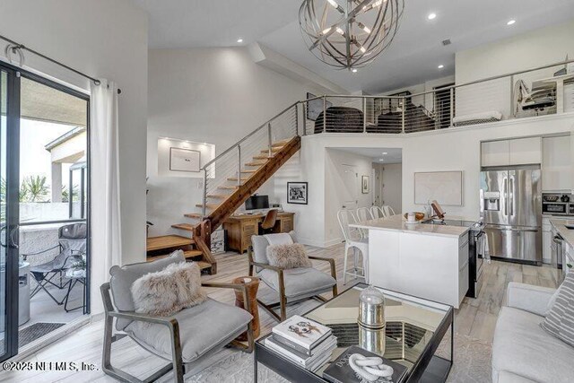 726 Spinnakers Reach Dr Unit 726, Ponte Vedra Beach, FL 32082 - living room with a high ceiling, stairway, recessed lighting, light wood finished floors, and a notable chandelier