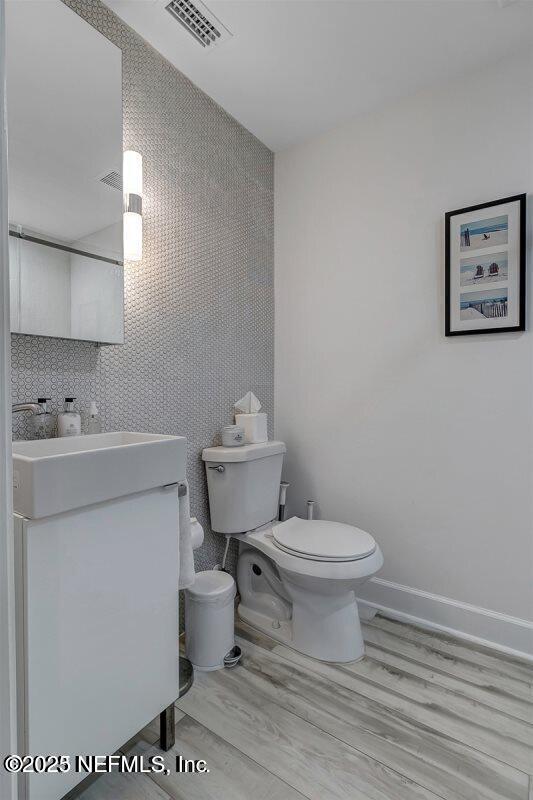 726 Spinnakers Reach Dr Unit 726, Ponte Vedra Beach, FL 32082 - bathroom with visible vents, wood finished floors, vanity, baseboards, and toilet
