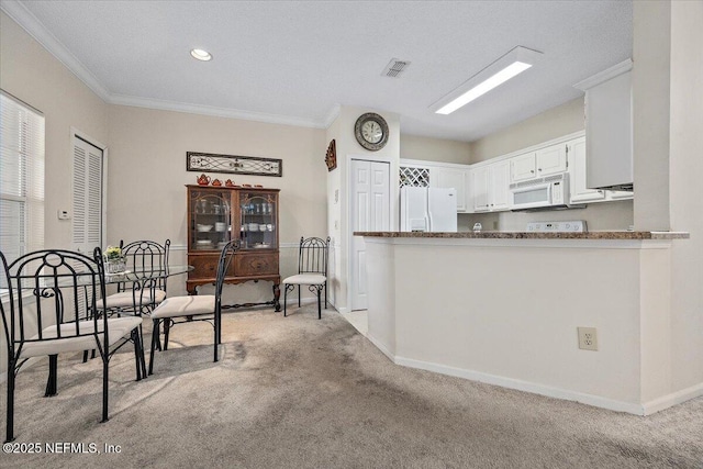 10000 Gate Pkwy Unit 714, Jacksonville, FL 32246 - kitchen with light colored carpet, white appliances, crown molding, and visible vents