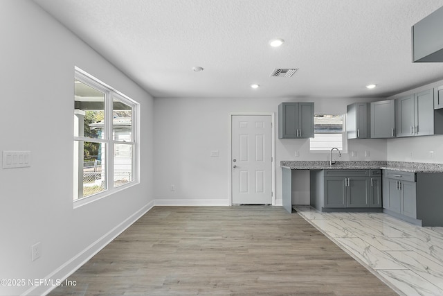 1539 E 26th St, Jacksonville, FL 32206 - kitchen featuring visible vents, baseboards, a healthy amount of sunlight, and gray cabinets