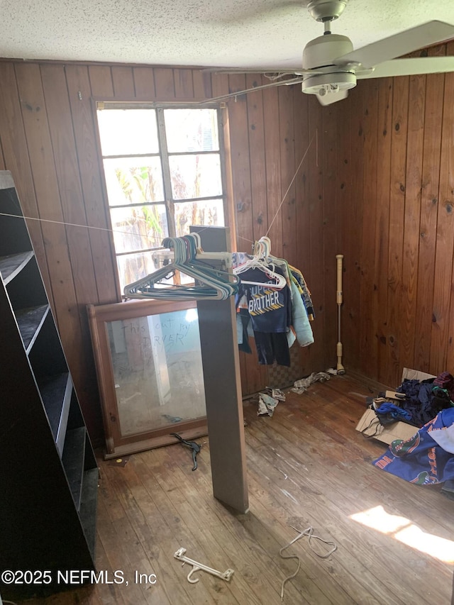 7823 Berry Ave, Jacksonville, FL 32211 - unfurnished dining area featuring wooden walls, a textured ceiling, a ceiling fan, and hardwood / wood-style flooring