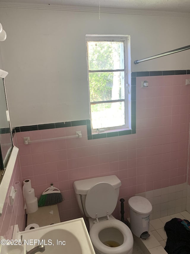7823 Berry Ave, Jacksonville, FL 32211 - full bathroom with a wainscoted wall, toilet, tile walls, crown molding, and tile patterned flooring