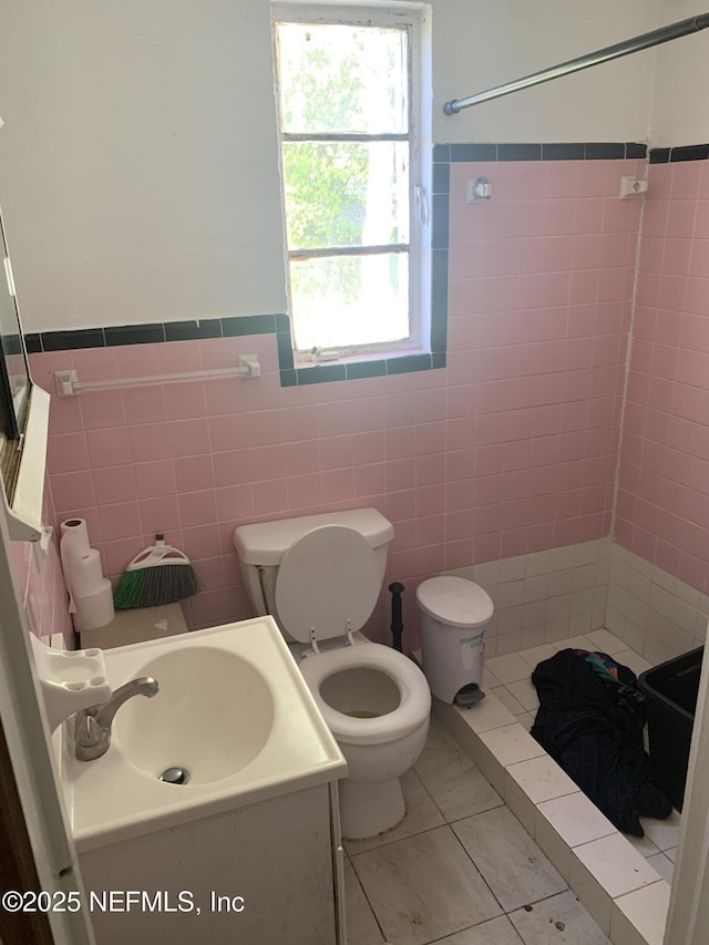7823 Berry Ave, Jacksonville, FL 32211 - full bathroom featuring toilet, vanity, wainscoting, tiled shower, and tile walls