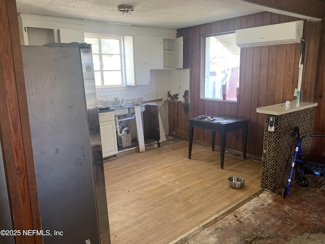 7823 Berry Ave, Jacksonville, FL 32211 - kitchen featuring freestanding refrigerator, a healthy amount of sunlight, light wood-type flooring, and a wall mounted air conditioner