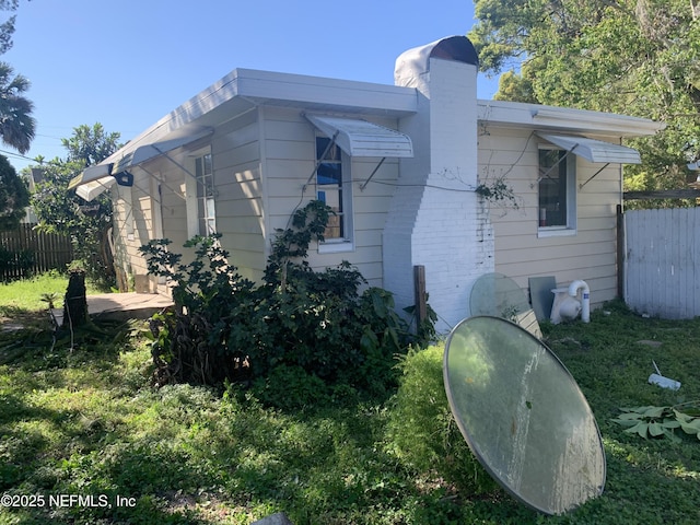 7823 Berry Ave, Jacksonville, FL 32211 - view of home's exterior featuring a chimney and fence