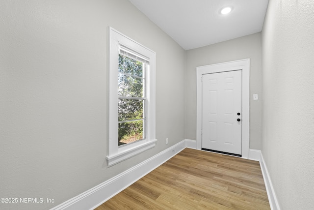 doorway featuring light wood-style floors and baseboards