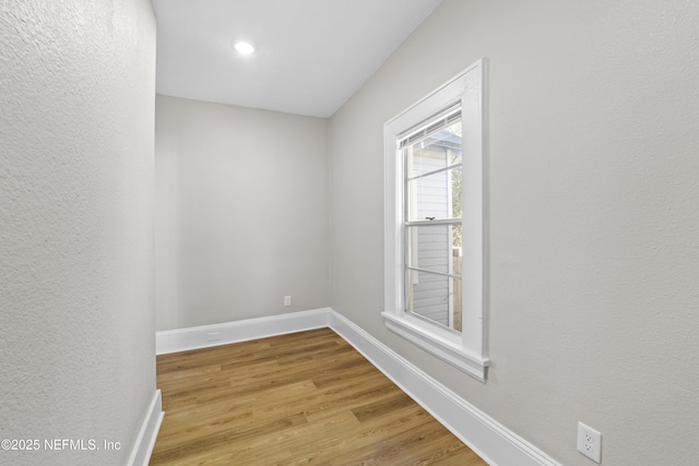 spare room with wood finished floors and baseboards