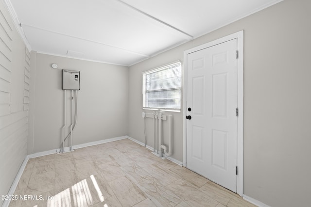interior space with laundry area, crown molding, baseboards, and marble finish floor