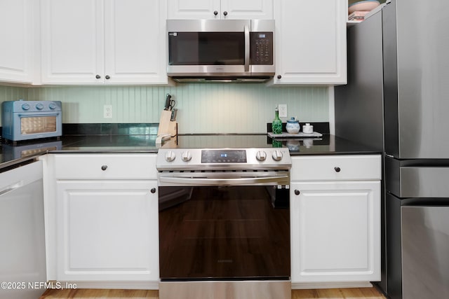 8539 Gate Pkwy W Unit 628, Jacksonville, FL 32216 - kitchen with dark countertops, white cabinets, and appliances with stainless steel finishes